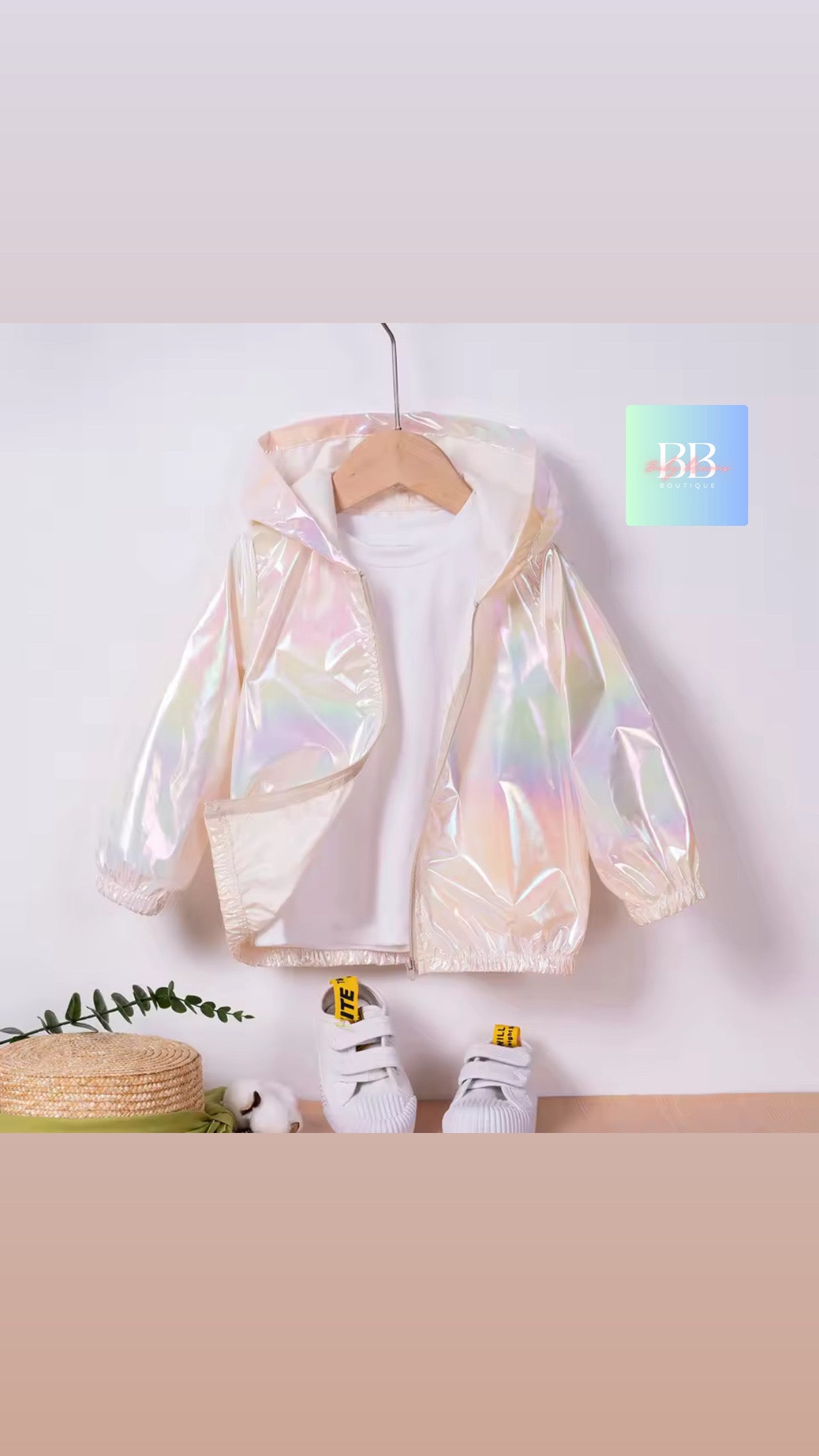 Holographic jacket on a hanger against a white wall with a beige floor.
