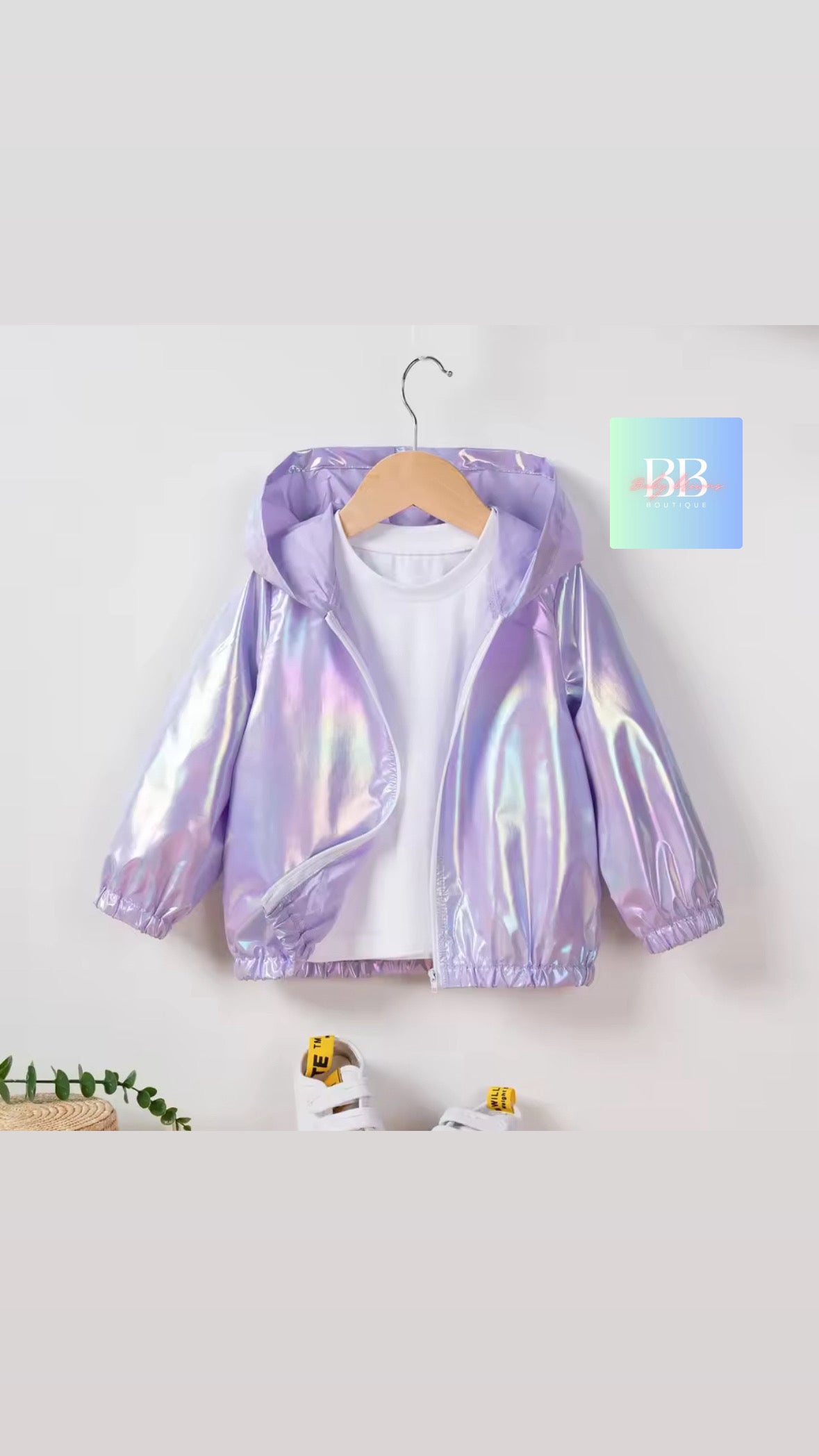 Holographic purple jacket on a hanger against a white background