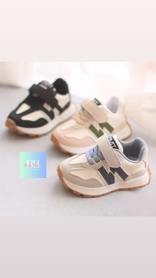 Three pairs of children's sneakers on a light background