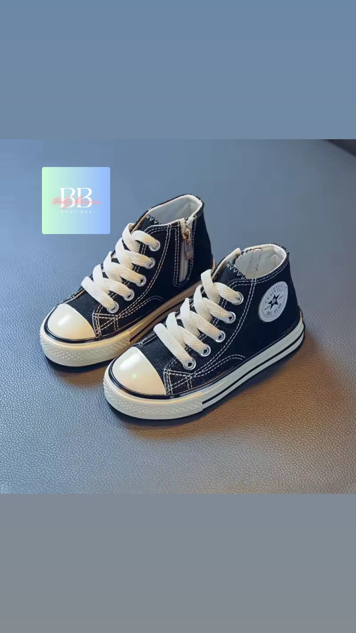Pair of navy blue high-top sneakers with white laces on a light blue background