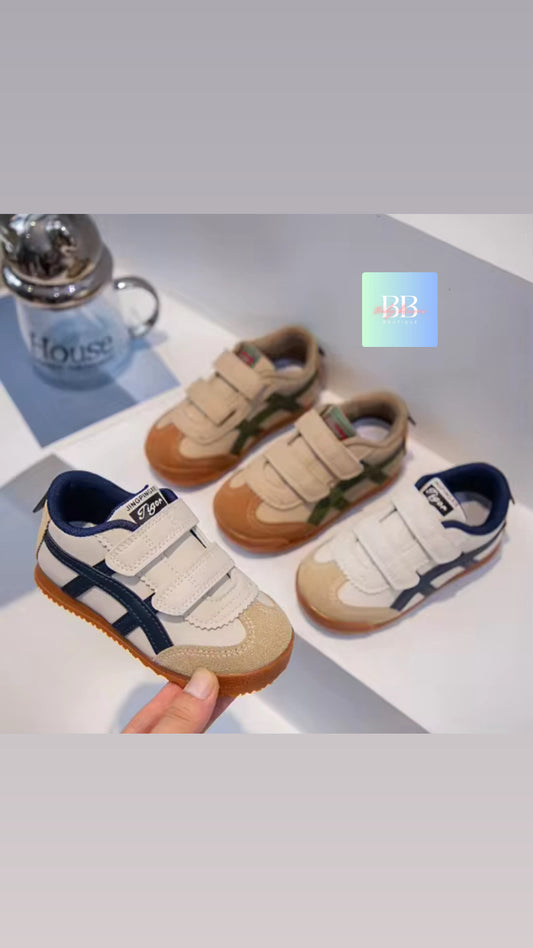 Pair of children's shoes with brown soles and navy accents on a light background