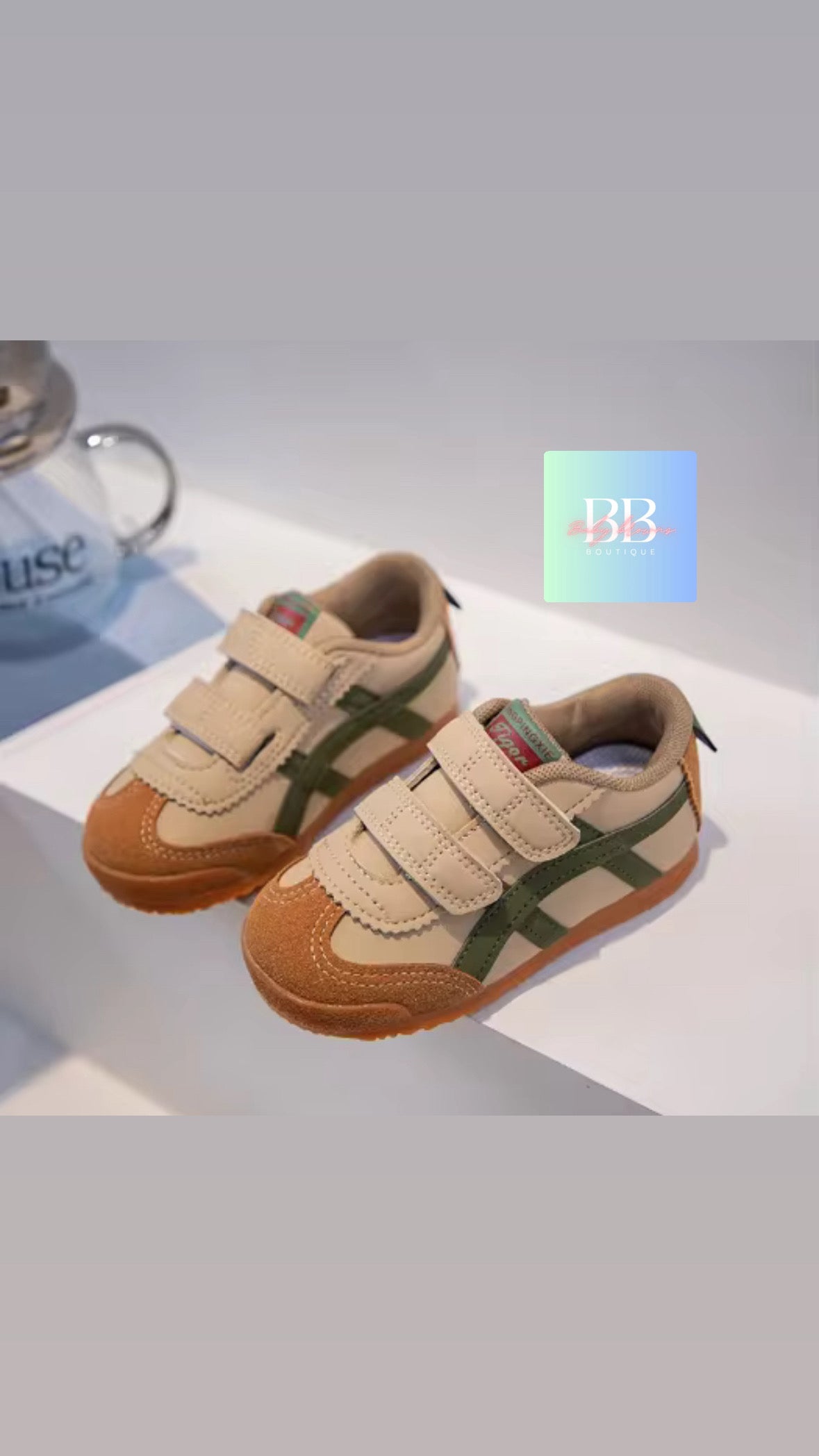 Children's shoes with brown and green design on a light gray background