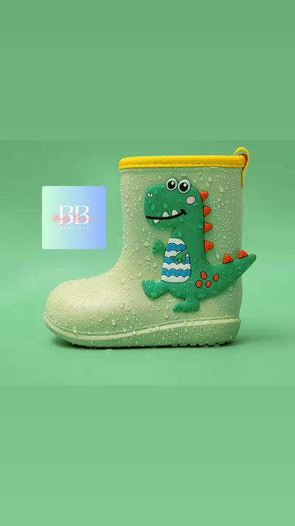 Children's rain boot with dinosaur design on a green background