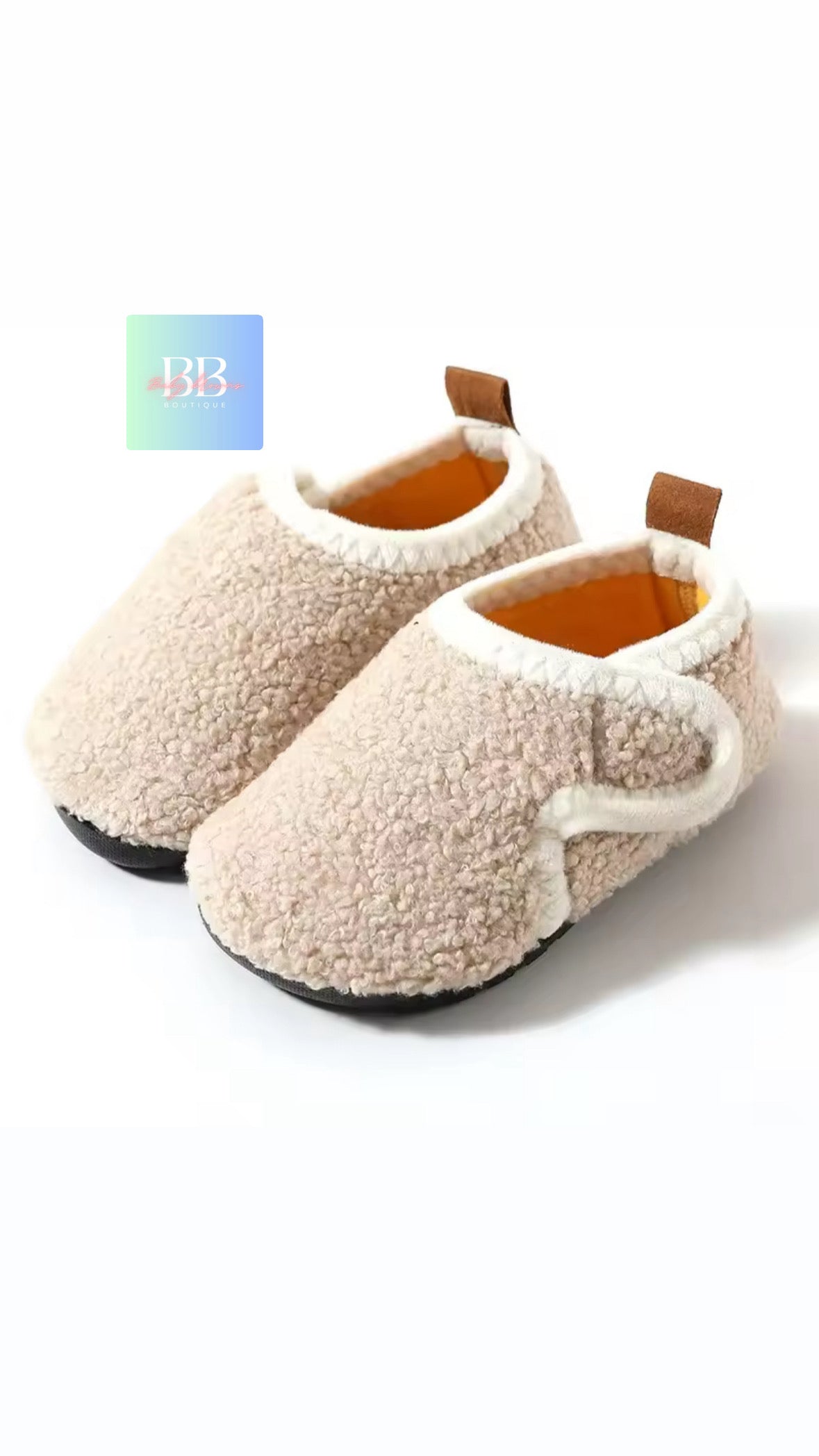 Pair of beige slippers with brown soles on a white background
