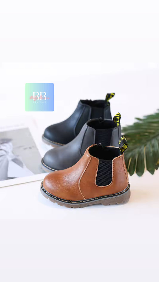 Pair of children's boots on a white surface with a blurred background