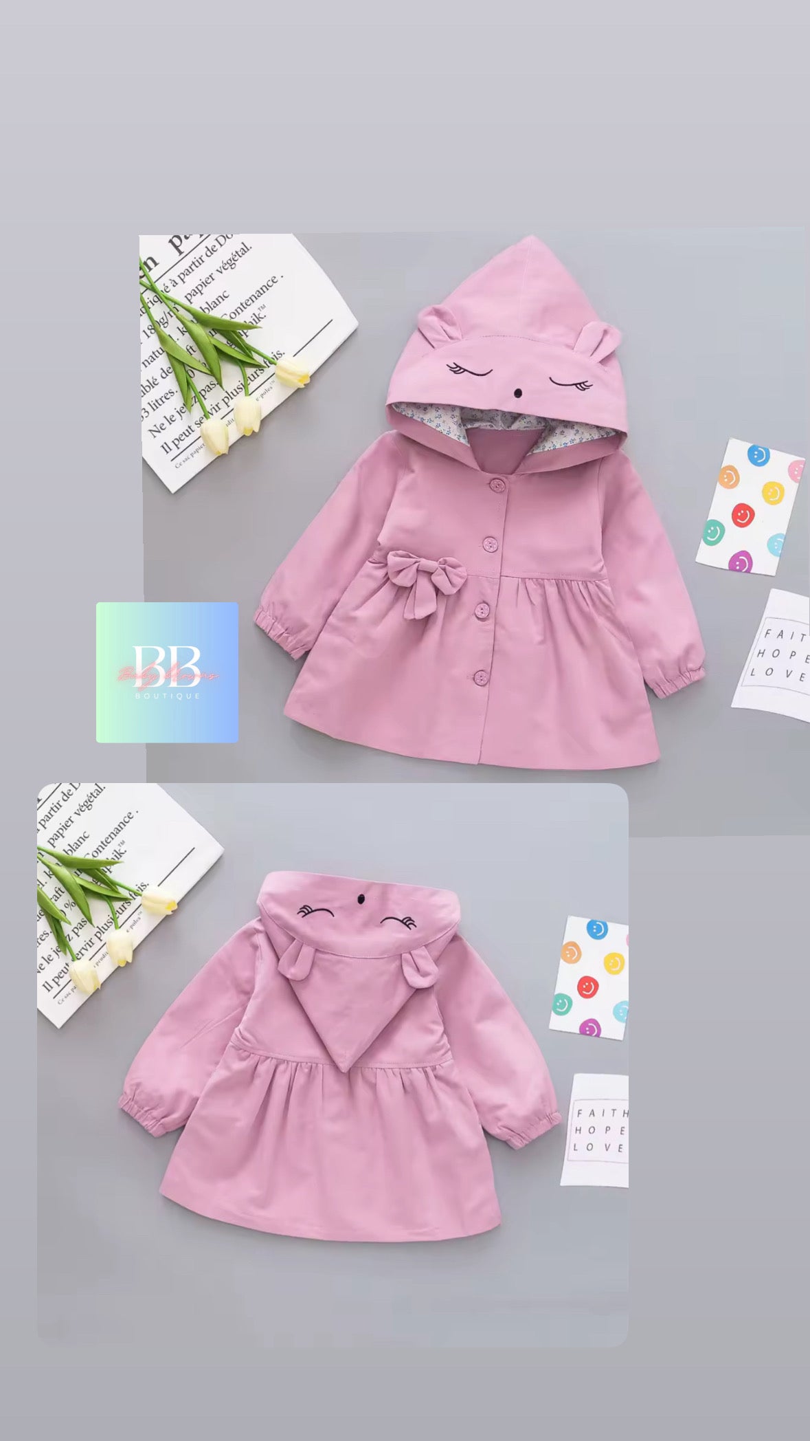 Pink children's coat with cartoon face design on a gray background