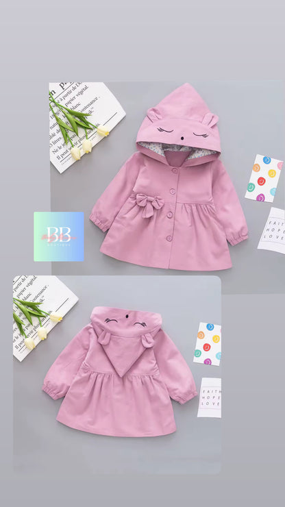 Pink children's coat with cartoon face design on a gray background