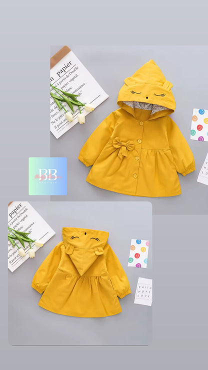 Yellow children's raincoat with a hood on a gray background