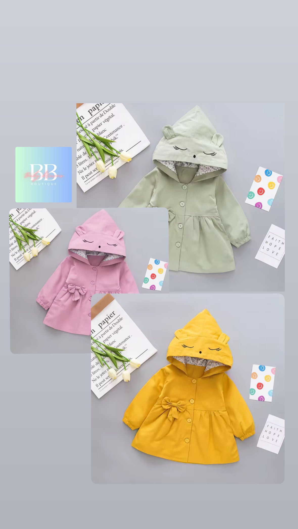 Three children's hoodies in pink, green, and yellow on a gray background with decorative elements.