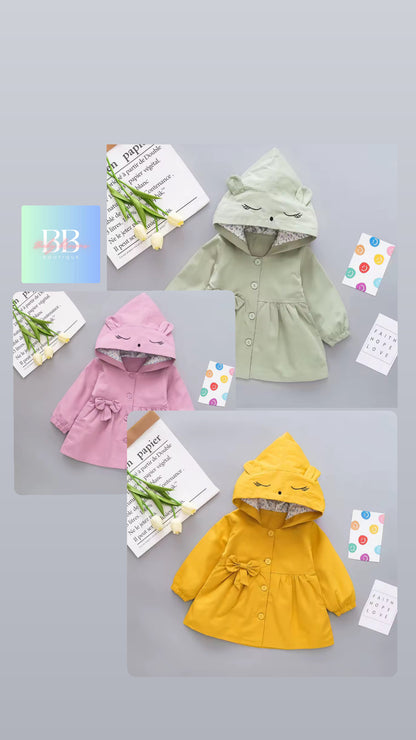 Three children's hoodies in pink, green, and yellow on a gray background with decorative elements.