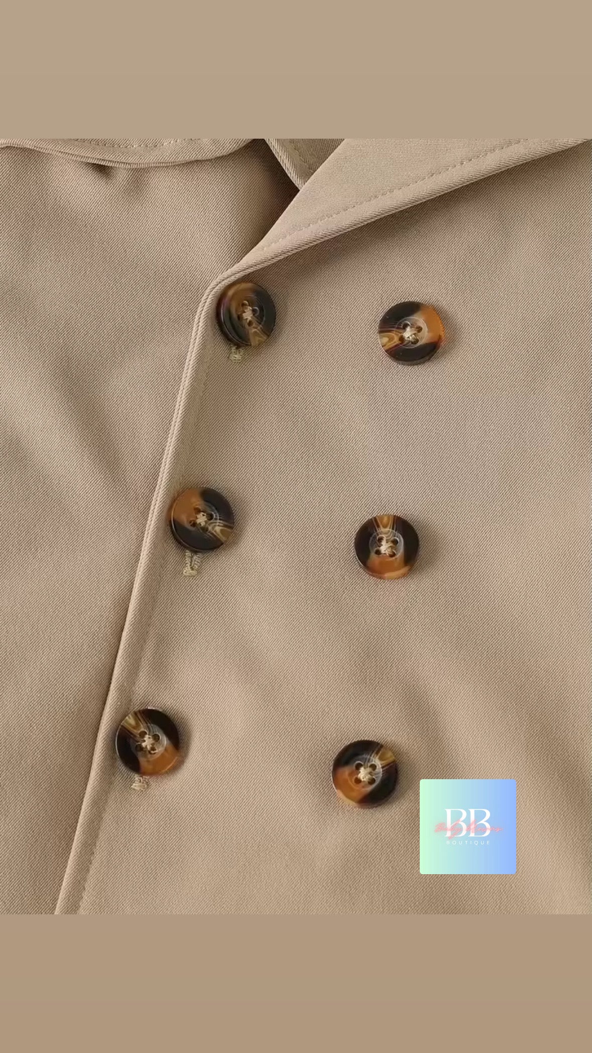 Close-up of a beige coat with tortoiseshell buttons on a beige background