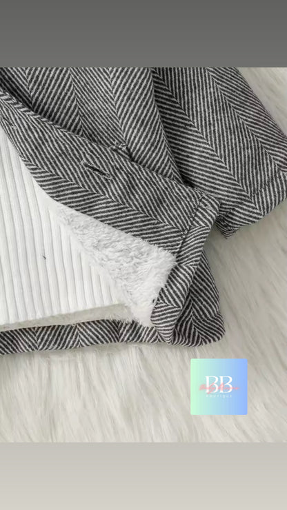 Textured fabric with a herringbone pattern on a light wooden surface
