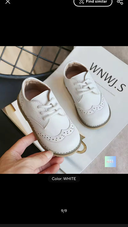 White shoes being held with a branded box in the background