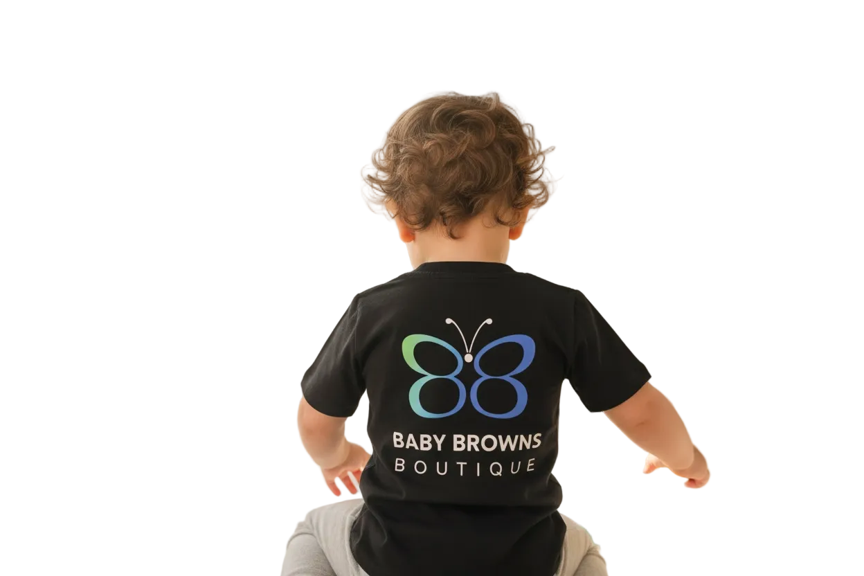 Child wearing a black t-shirt with a colorful butterfly logo and 'Baby Browns Boutique' text, sitting on the floor in a bright room.