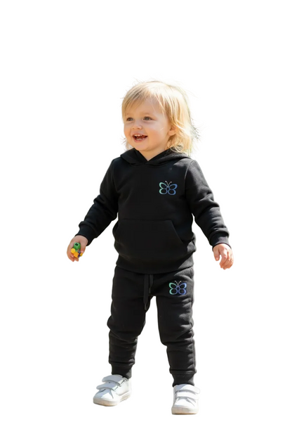Child wearing a black hoodie and pants with a blue flower design on a white background