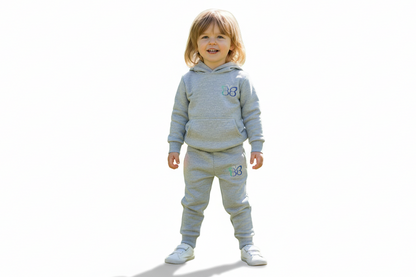 Child wearing a gray tracksuit with a butterfly design on a white background